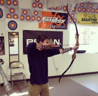 a man with a bow and arrow in a room