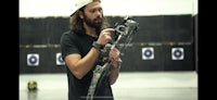a man holding a bow and arrow in front of a target