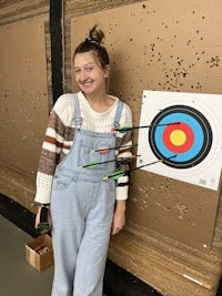 a girl posing in front of an archery target
